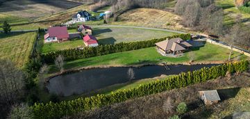 Dom z pełnego bala z zarybionym stawem