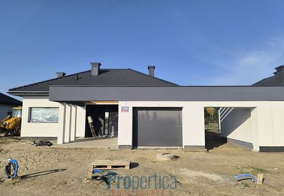 Dom z garażem i wiatą w bryle budynku