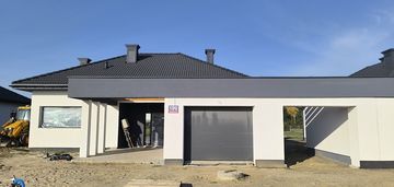 Dom z garażem i wiatą w bryle budynku