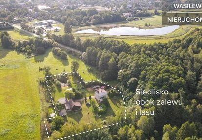 Siedlisko z dwoma domami obok zalewu i lasu