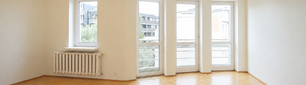 Jasny salon z dużymi przeszkleniami i garderobą