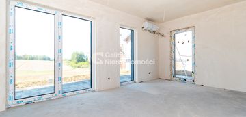 Skrajna szeregówka w zieleni – garaż i taras.