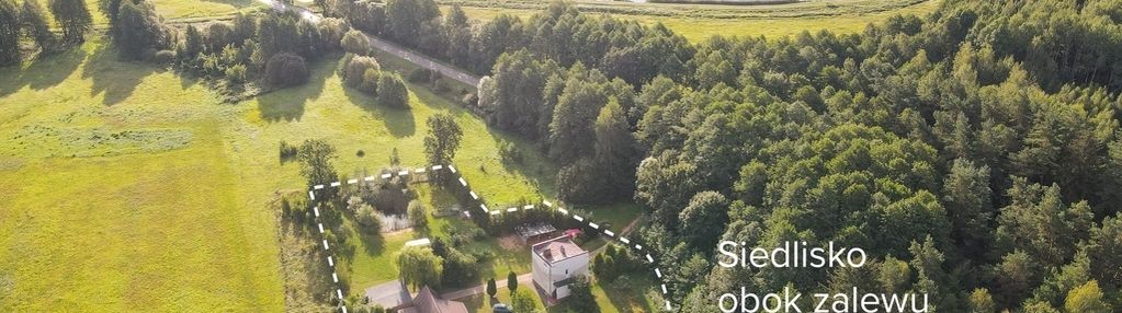Siedlisko z dwoma domami obok zalewu i lasu