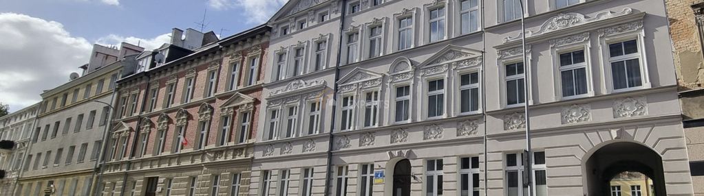 W kamienicy z zrobioną elewacją i dachem.