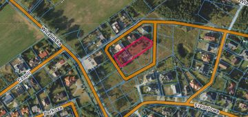 Działka blisko lasu w otoczeniu niskich domów.