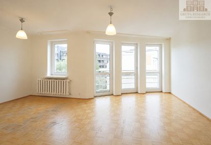 Jasny salon z dużymi przeszkleniami i garderobą