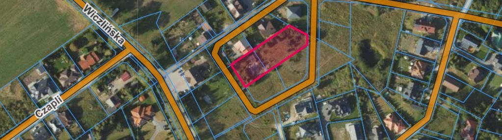 Działka blisko lasu w otoczeniu niskich domów.