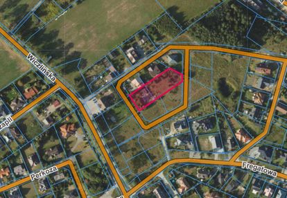 Działka blisko lasu w otoczeniu niskich domów.