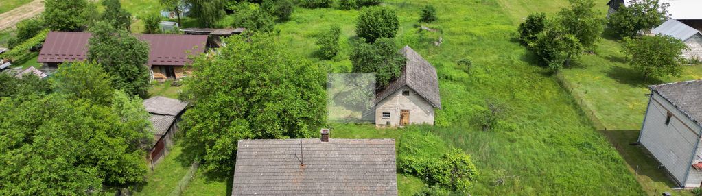 Duża działka z drewnianym domkiem i budynkiem gosp