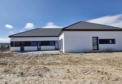 Nowoczesny dom parterowy w zabudowie bliżniaczej.