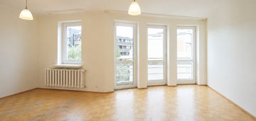 Jasny salon z dużymi przeszkleniami i garderobą